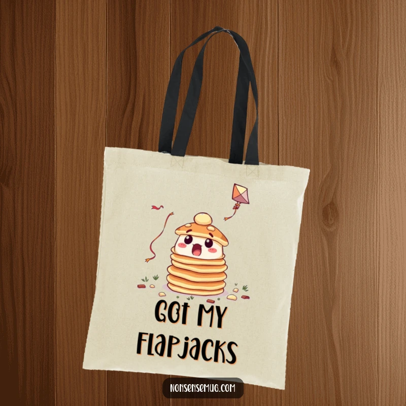 Funny tote bag with a surprised stack of pancakes attempting to fly a kite, perfect for carrying essentials humorously.